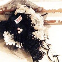 ハンドメイドのコサージュで帽子にアクセント。