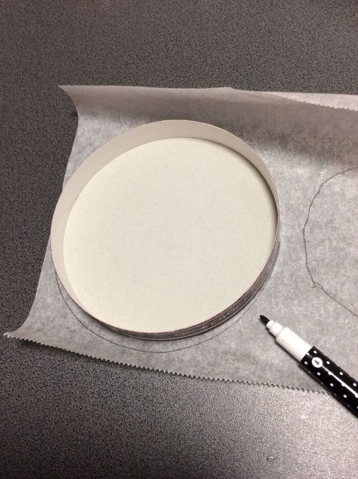 チーズの蓋の型をクッキングシートに写す。