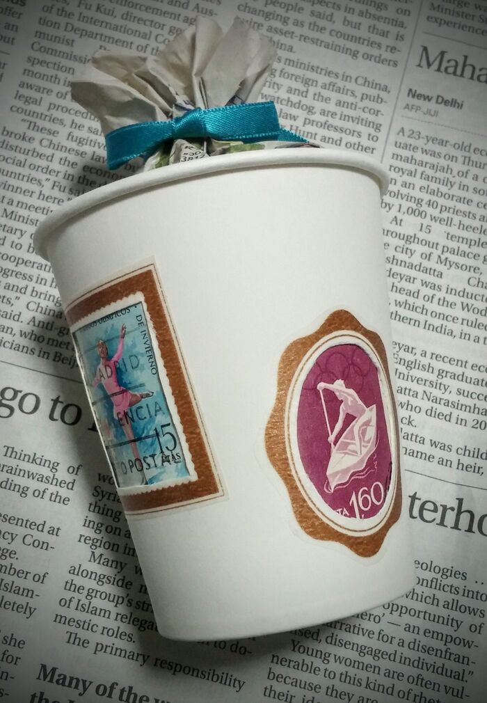 重ねた紙コップの間に切手を挟みました