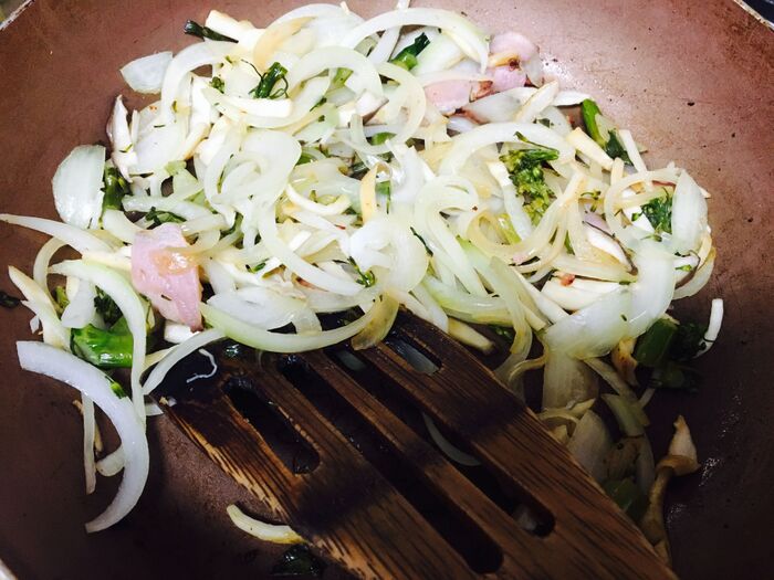 具材をベーコンから順に炒め合わせる。