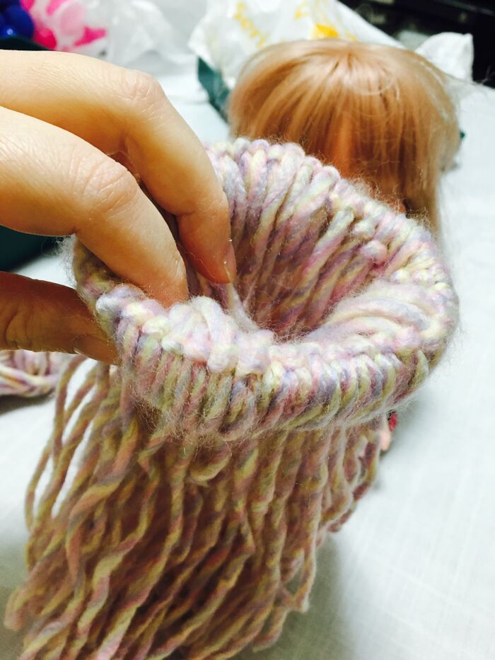 ベルトの輪に通すように毛糸を引っ張る。