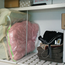 突っ張り棒を使って下の布団を取り出しやすくする収納術