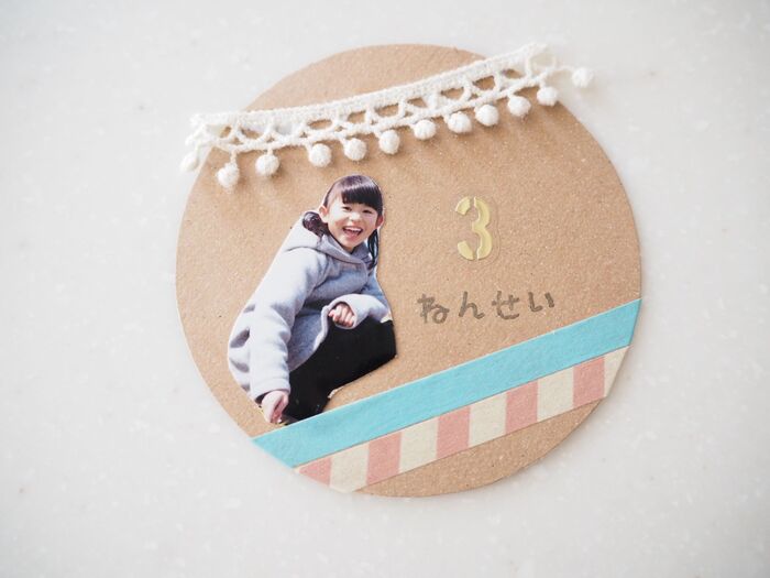 丸く切ったクラフトボードに飾り付け。