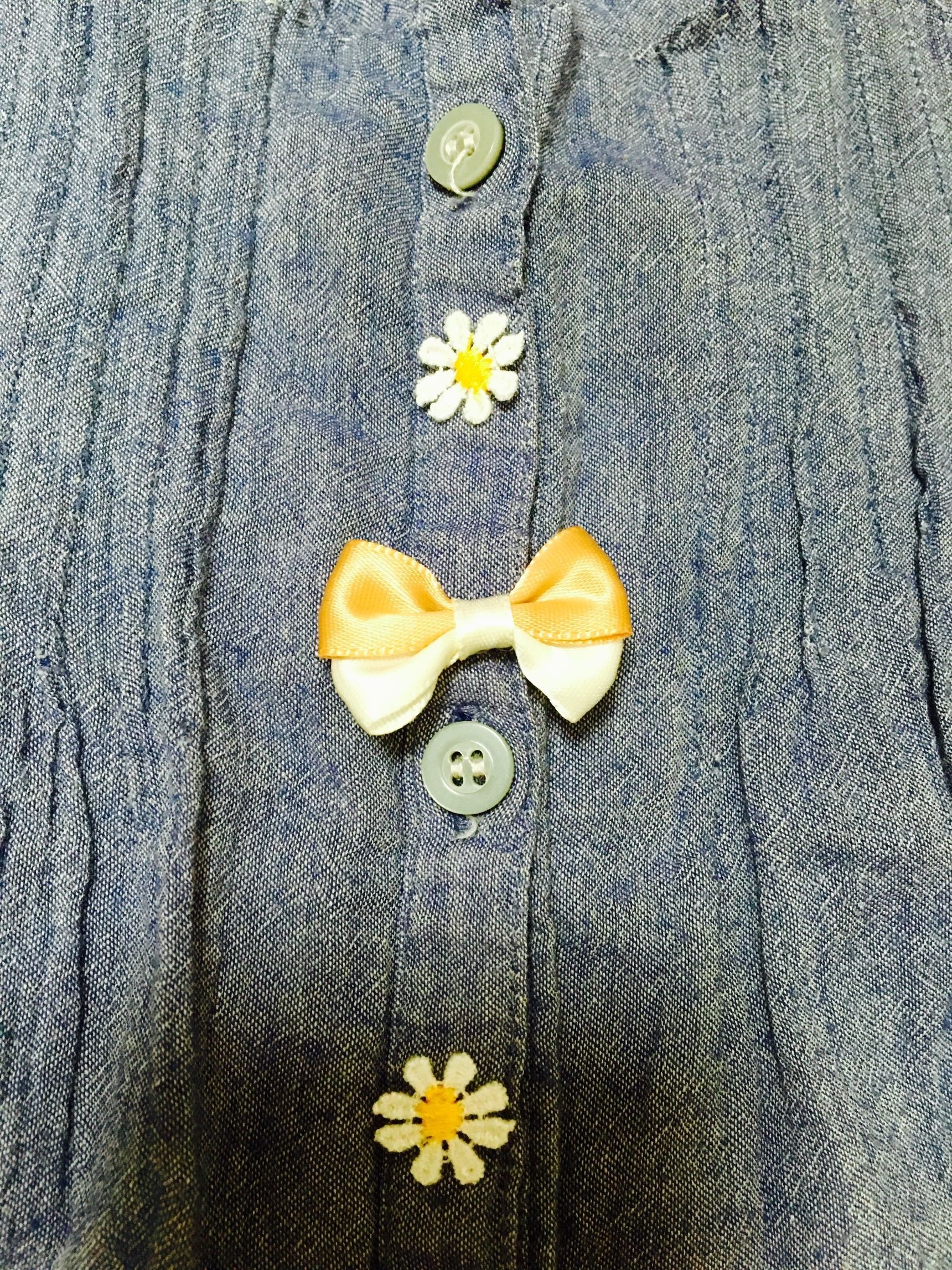 ボタンとボタンの間に、リボンと花のモチーフを縫い付けました！