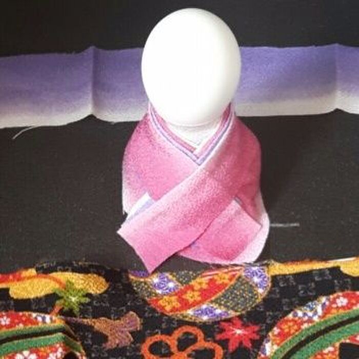 3、人形の胴体に衣装を着せる。