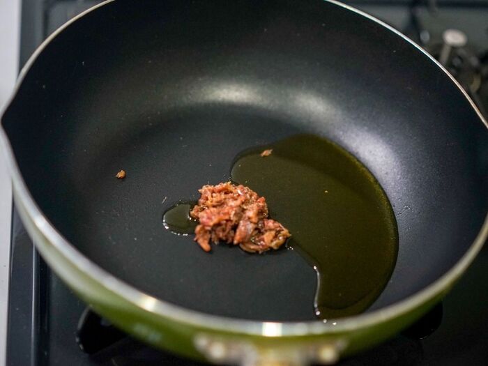 フライパンにオイルとアンチョビを入れて火にかける