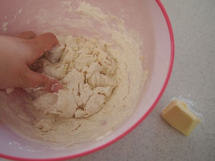 ②ボウルに水、無塩バターの順に加えて生地をまとめます