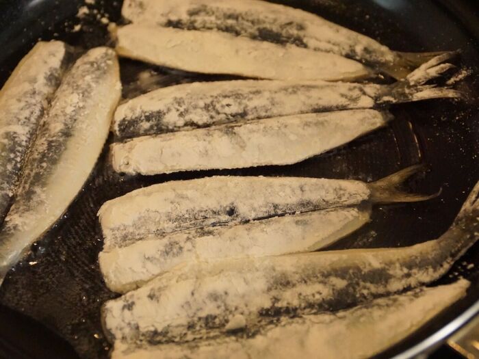 いわしに薄力粉をまぶし、焼く