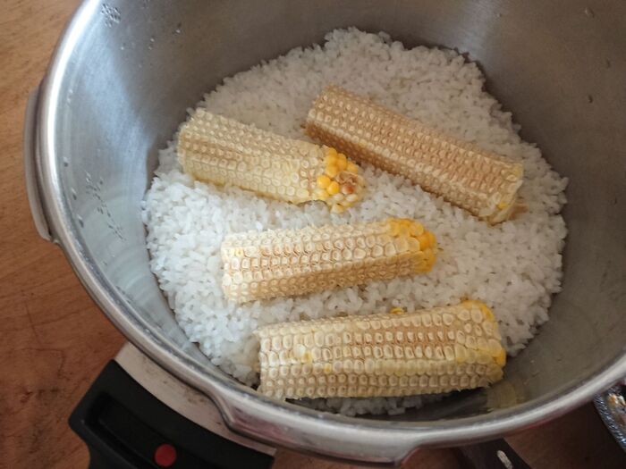 とうもろこしの芯をのせてご飯を炊きます