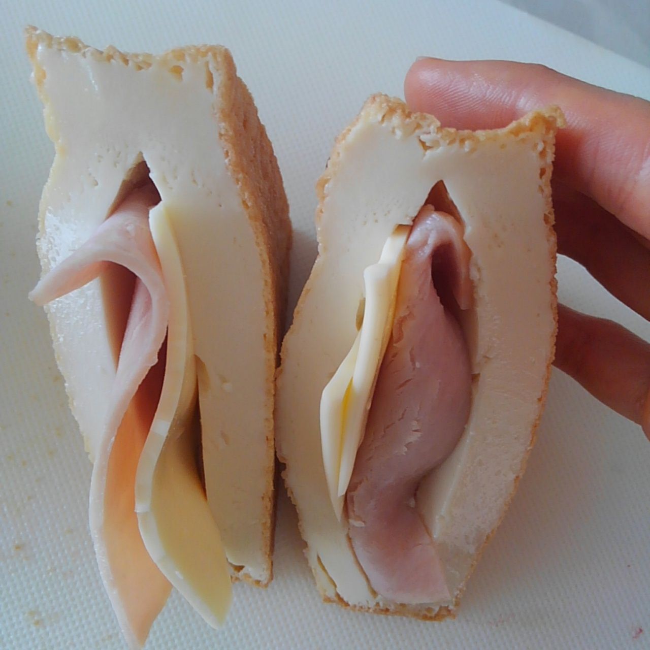 絹厚揚げを三角に切る。切り込みを入れてハムとチーズをはさむ。