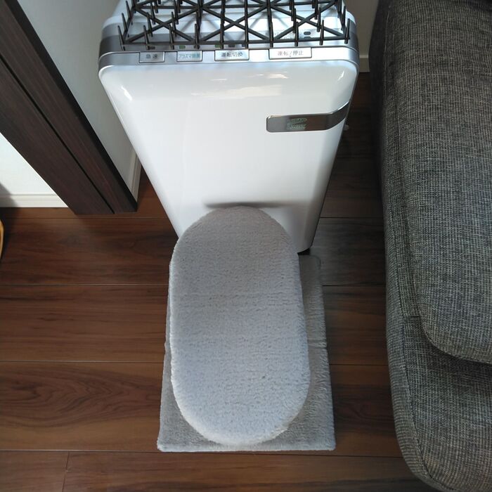 空気清浄機を壁と爪とぎポールではさみます