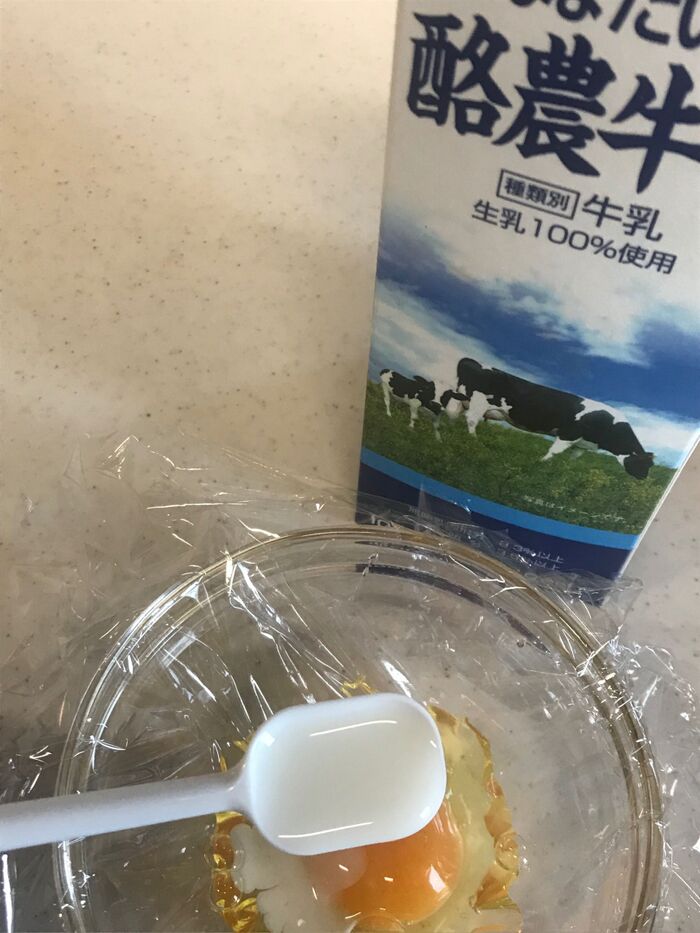 ラップの上に直接玉子を割り入れ、牛乳小さじ1を入れる