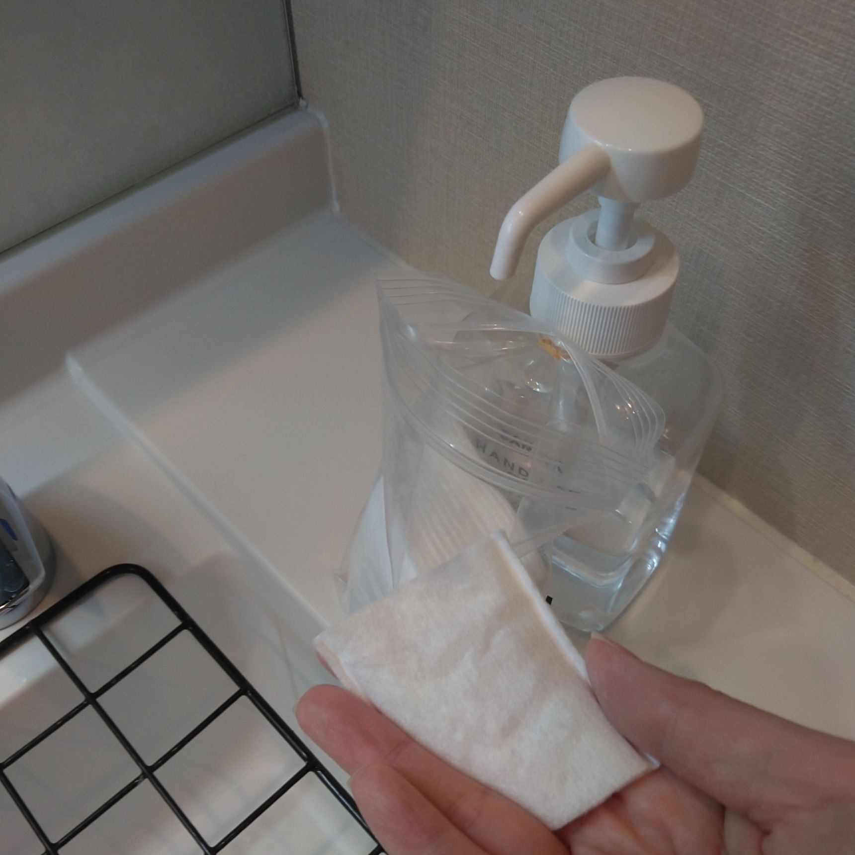 除菌ジェルのボトルにコットン入りのビニール袋を輪ゴムで固定します