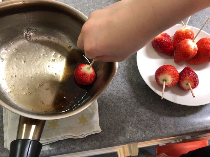 いちごとパイナップルを砂糖液にくぐらせる