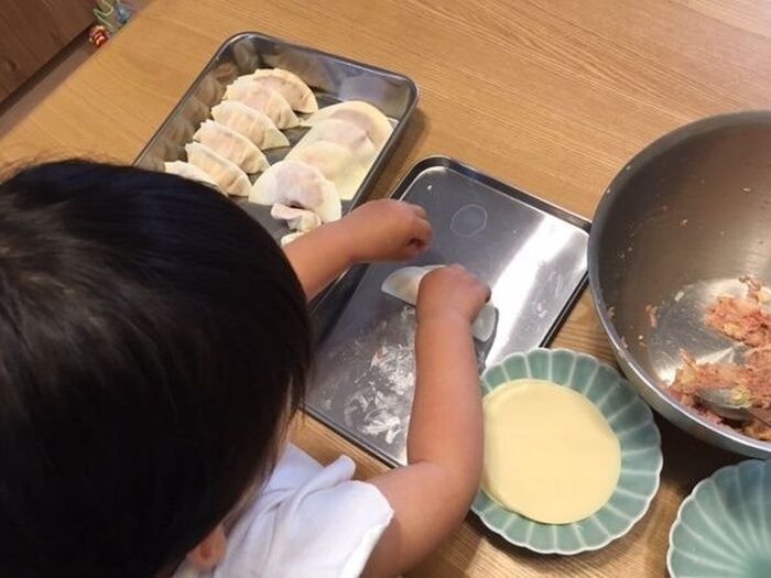 ③皮の縁に水をつけ、バッド上でぺたんと半分に折り返す ★ポイント