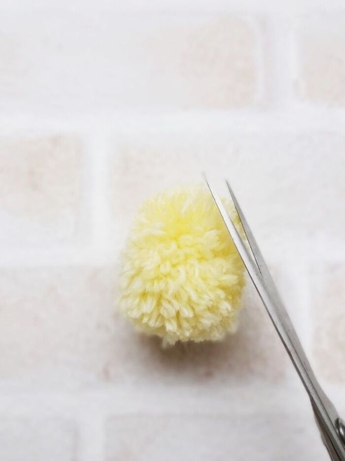 2)巻き具から取り出したポンポンの形をハサミで整えます