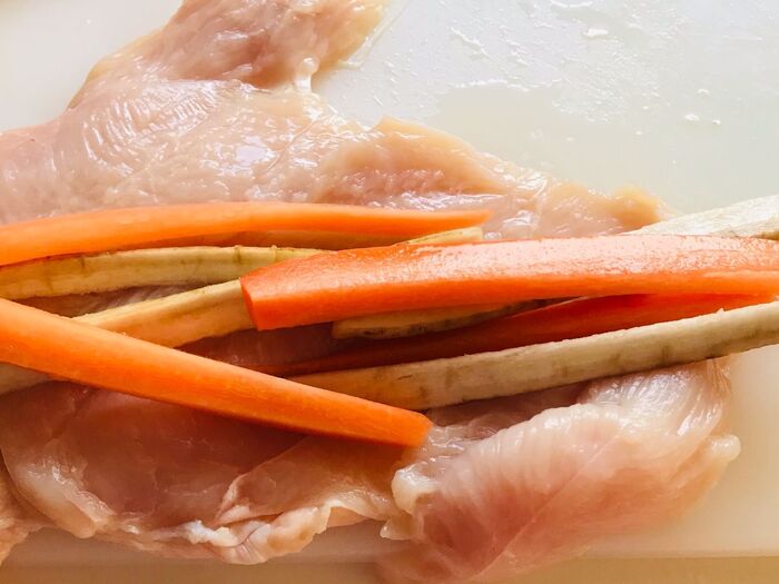 鶏胸肉を開いて棒状に切った牛蒡人参を巻きます。