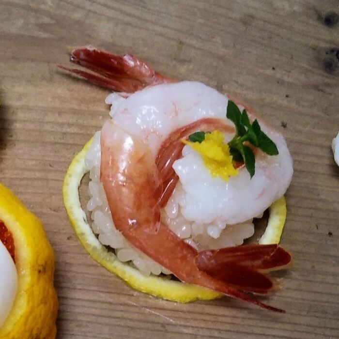 ⑤ラップに甘海老をのせる→丸く握った酢飯をのせ→ラップを絞って形を整え→器にゆずの皮の輪切りを置いて盛り付け→すりおろしたゆずの皮をとミントを添える。