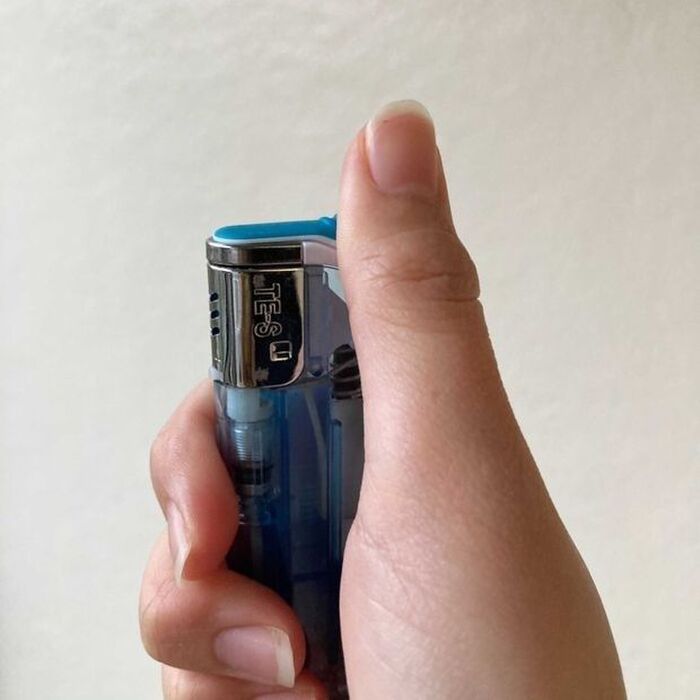 3)-1 火気のない屋外でライターのレバーを引き、火が消えるまで待つ