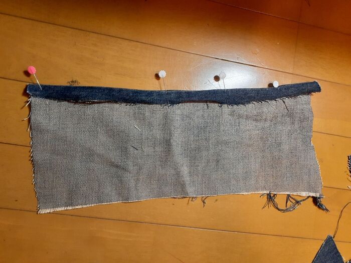 ①ジーンズの脚の部分の縦の縫い目を内側に折り縫う。