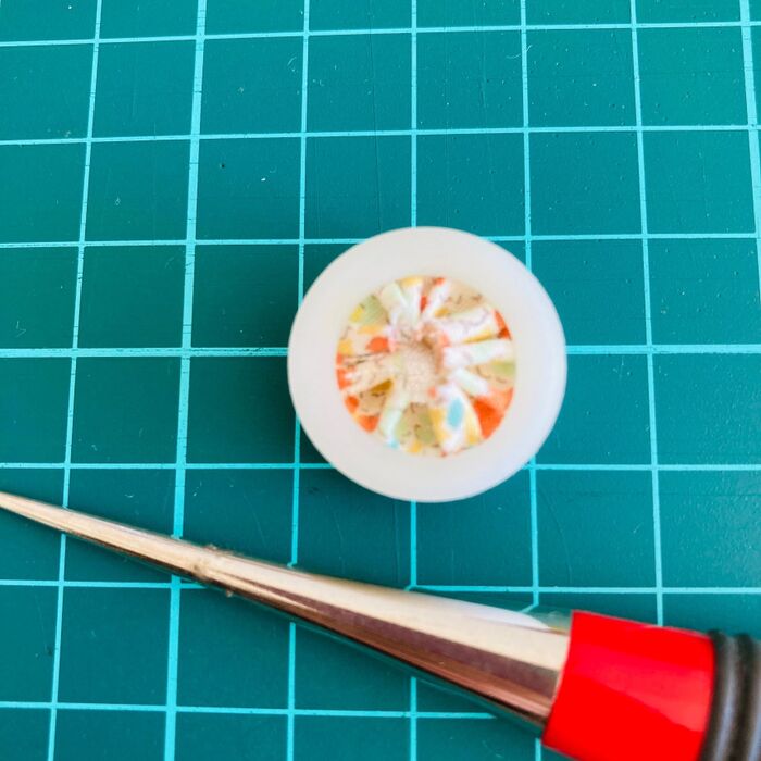 ②カットした布を台座の真ん中にのせてボタンを押し込み布を中央に寄せる。