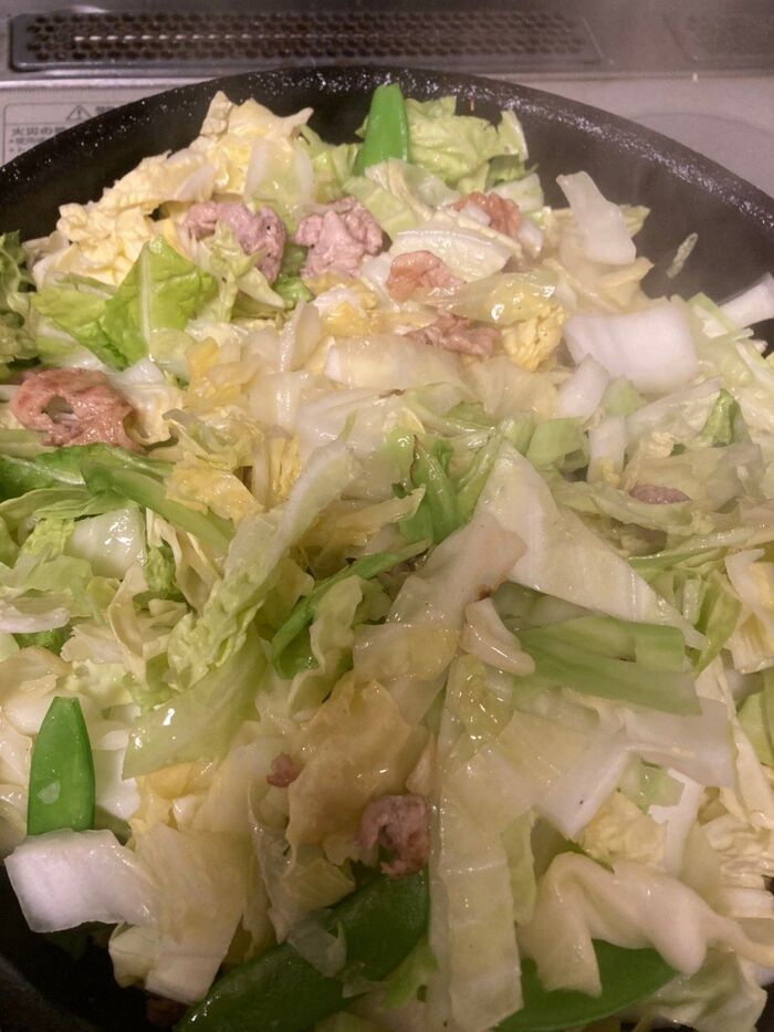 フライパンで豚肉と白菜、キャベツ、絹さやを炒める