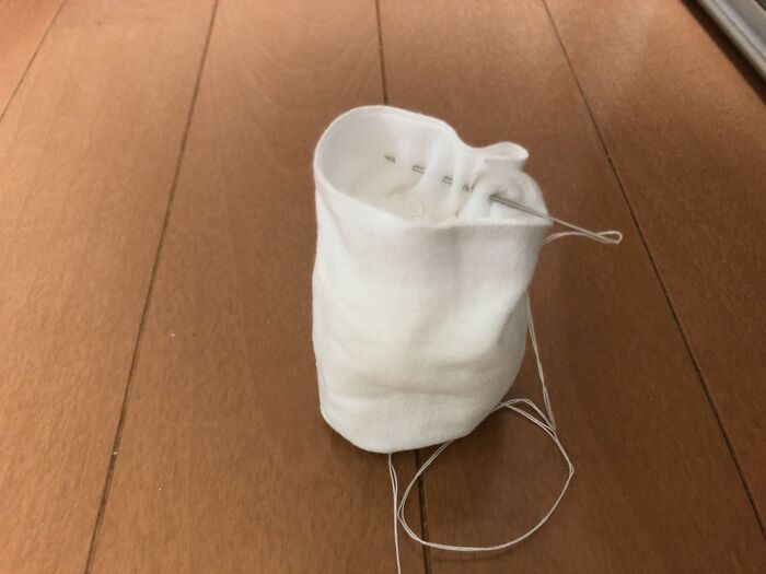 ペレットを入れたら内側から縫い代1㎝で縫い、同様に糸を引っ張り袋口を軽く絞ります