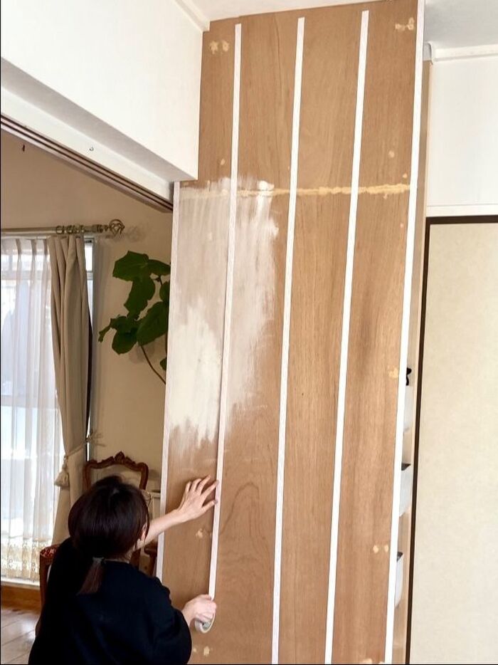 収納壁に両面テープを貼る。