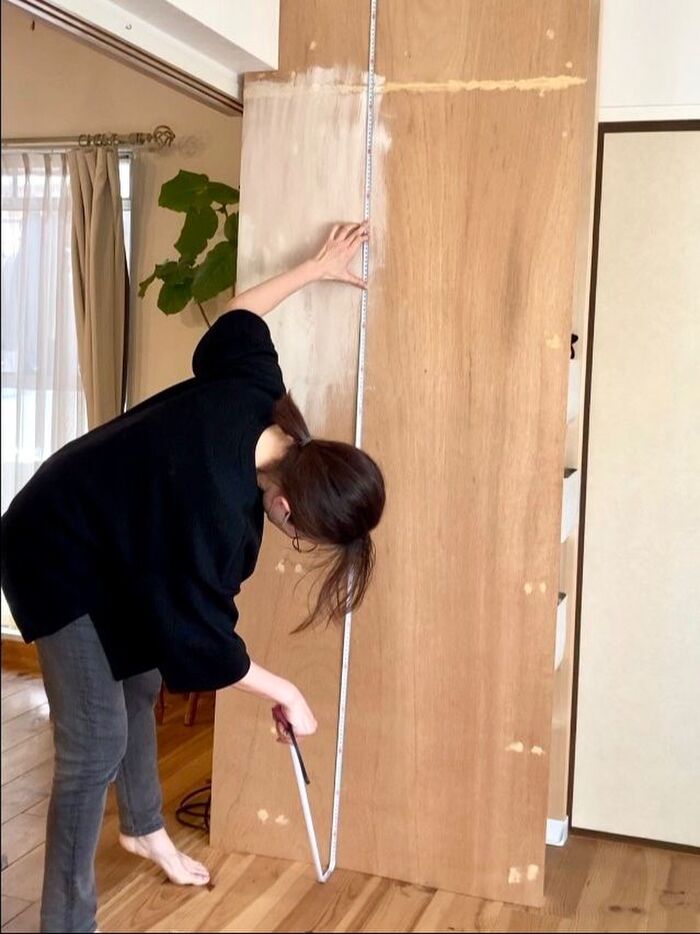 壁紙を用意するため、収納壁の高さを測る。