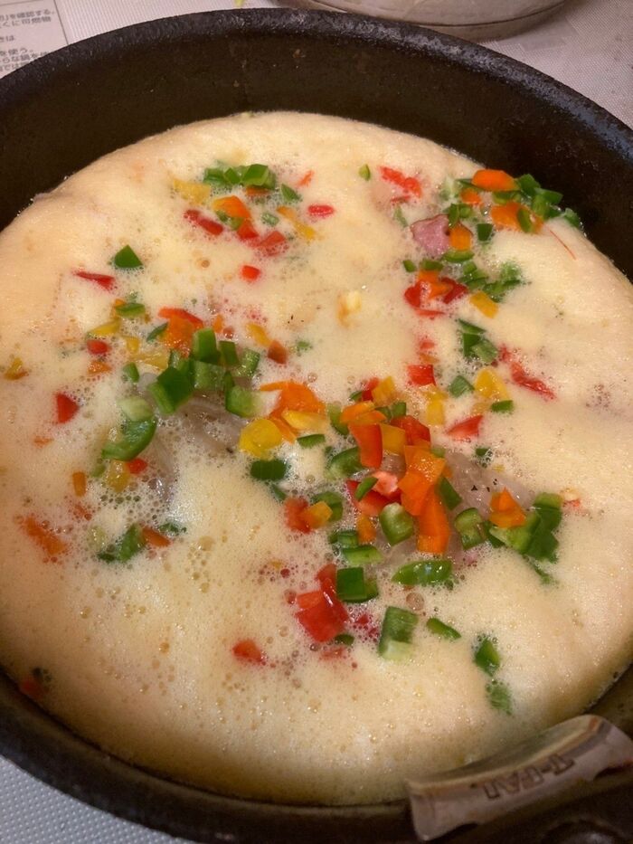 中火のフライパンにオリーブオイルと卵液を半分流し込み、具材を乗せて焼きます