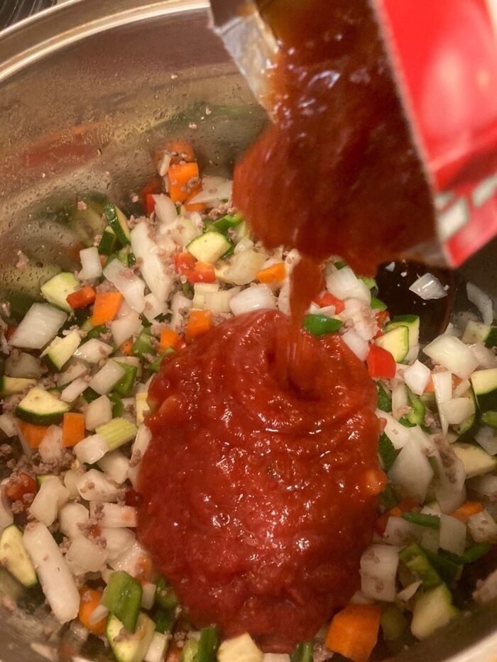 粗くつぶしたトマトのパックを加えます