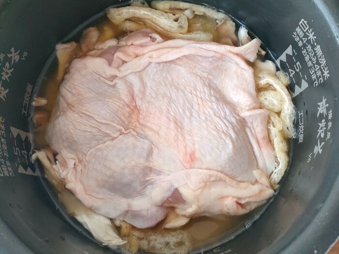炊飯釜に炊き込みご飯材料と鶏肉を入れます。