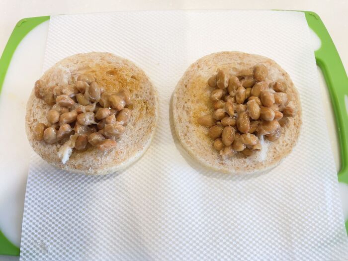 【キムチ納豆ちりめんじゃこトースト】イングリッシュマフィンにごま油をぬり、納豆を乗せます