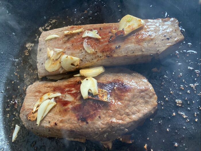 フライパンにオリーブオイルを入れ、ニンニクと一緒にお肉を両面こんがり焼きます♪