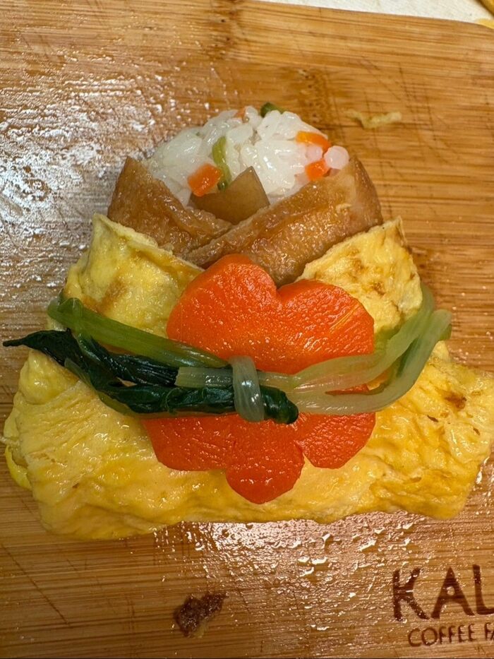 人参を乗せたらお出汁で煮た三つ葉で帯を結びます。