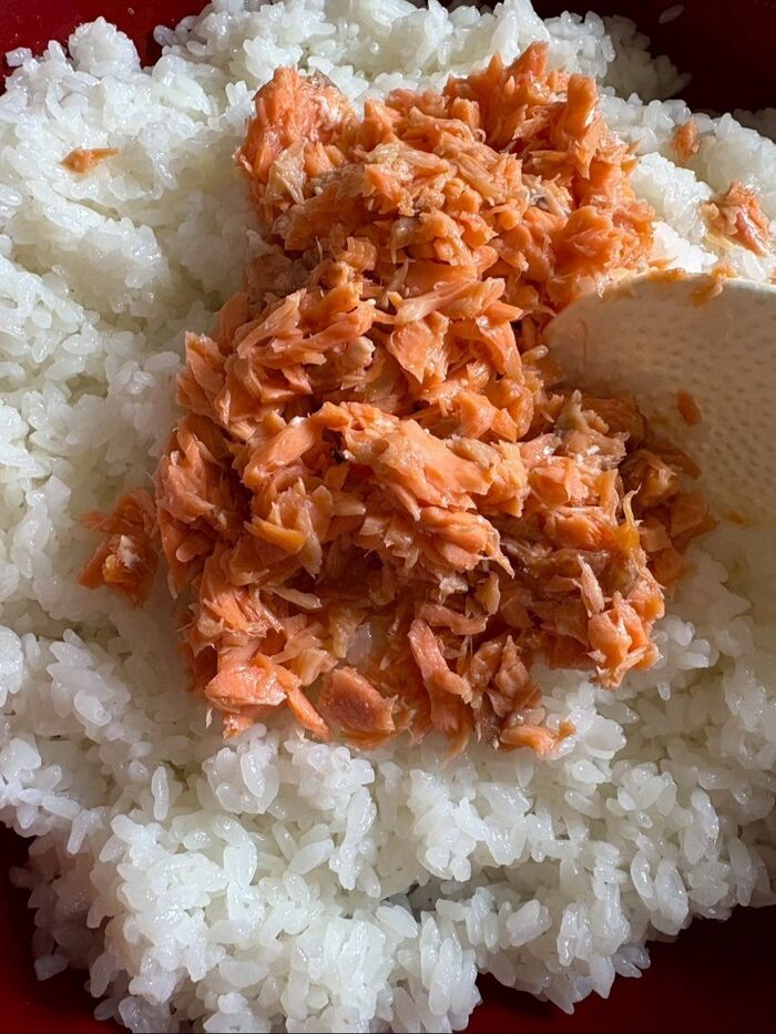 寿司酢を振りかけ酢飯を作り、ほぐした鮭を入れてさっくり混ぜ合わせます