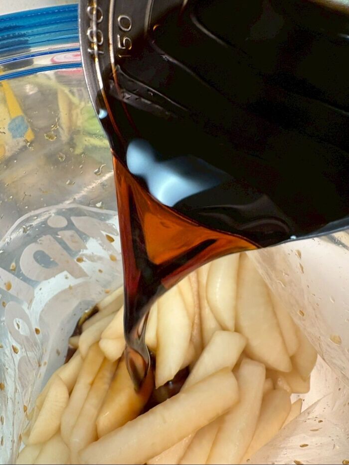 保存袋に大根を入れて、麺つゆとカンタン酢を加えてよく揉みます。