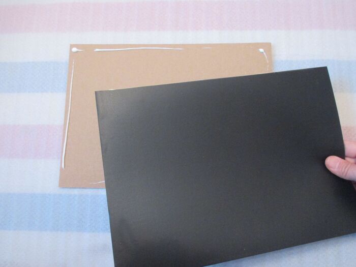 ⑥フレームに付属の厚紙に黒板をボンドで貼る。