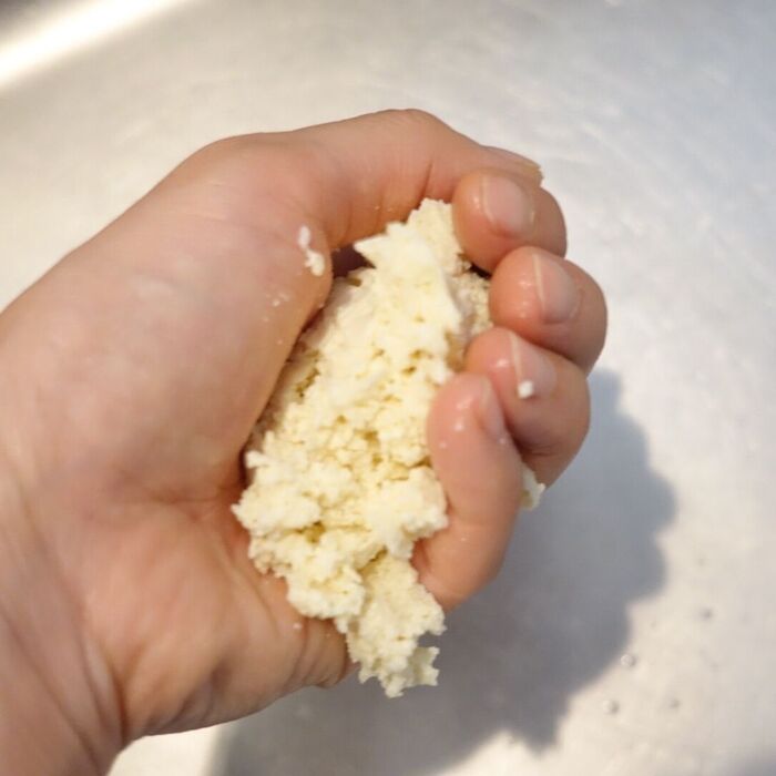 解凍した木綿豆腐の水気を絞る。