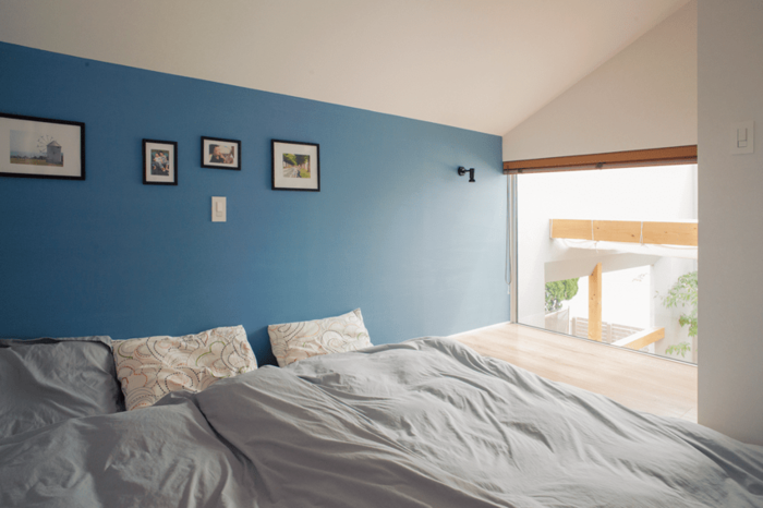 吹き抜けに面して窓を設けた寝室