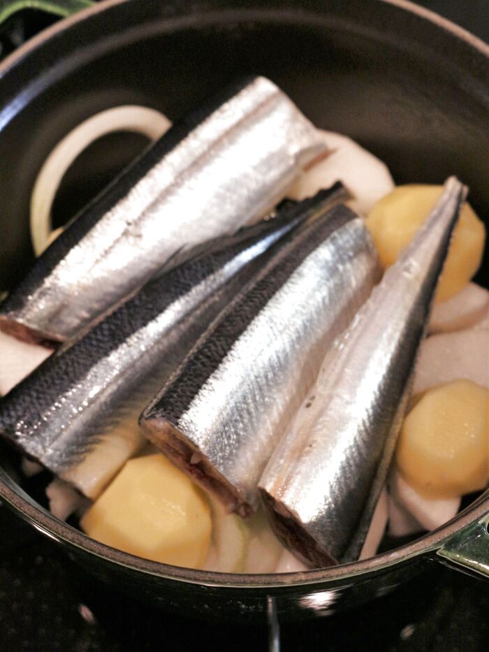 ②鍋の底に大根、じゃが芋、玉ねぎを分量の半分を敷き詰めて、次にさんまを乗せ、最後に残りの野菜を乗せる。