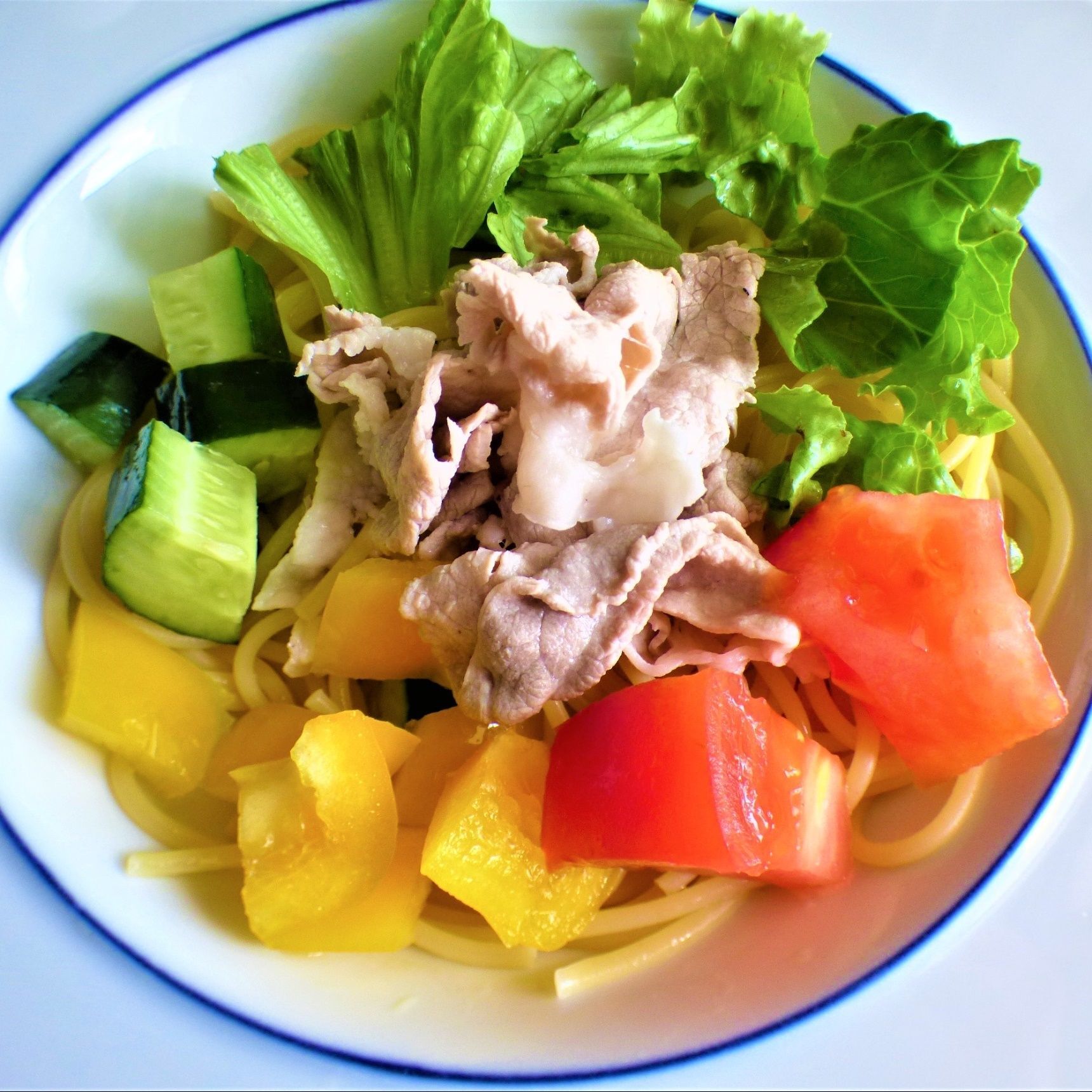 パスタを茹でたお湯で豚肉を湯がき冷水に入れ、野菜と盛りつける。