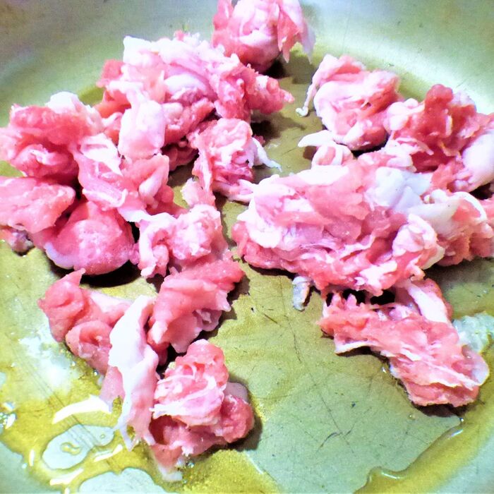 ごま油を熱したフライパンで豚肉を炒める。