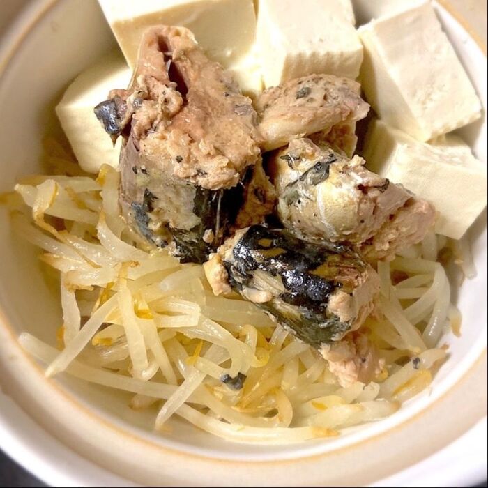 １．鍋にもやし、食べやすい大きさに切った豆腐、サバを缶汁ごと入れる。
