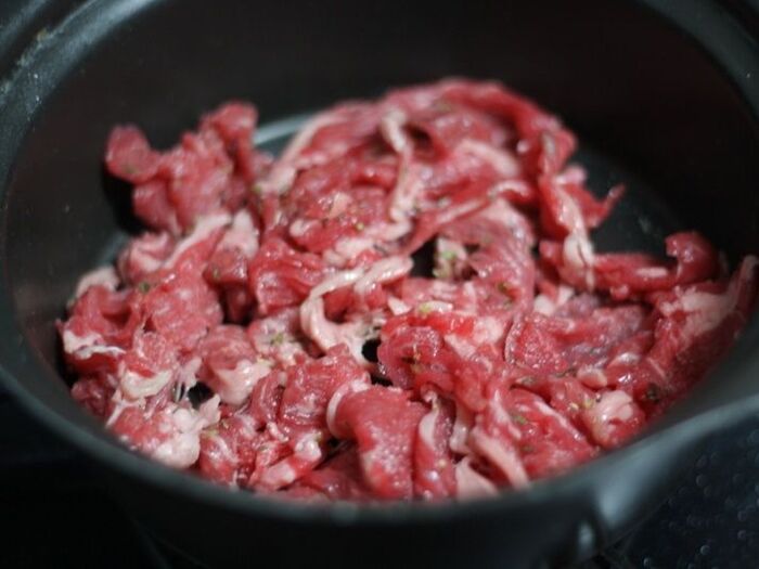 鍋に牛肉を広げる。