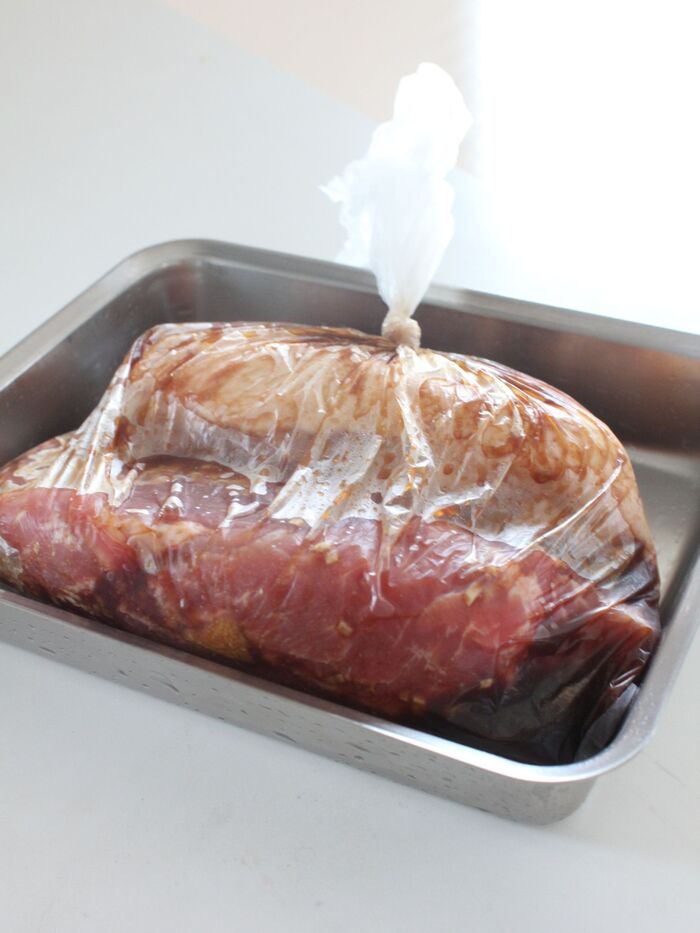 食品用のビニール袋に豚肉と混ぜた調味液をいれて空気を抜いてくくります