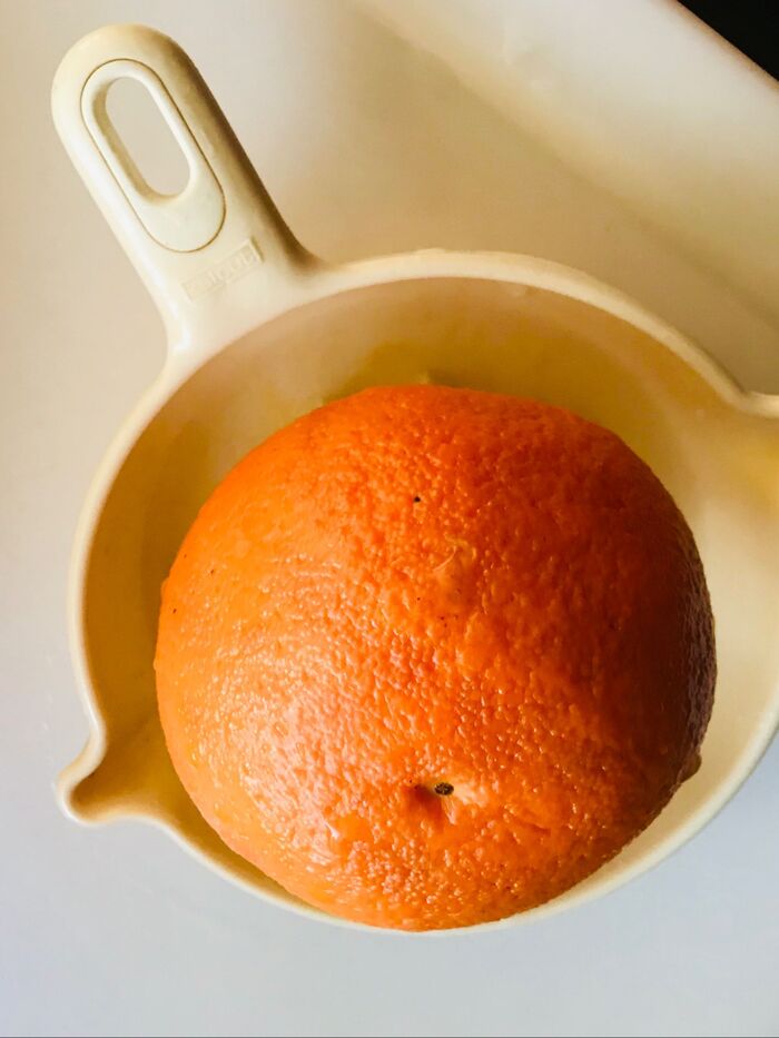 オレンジを横半分に切って果汁を絞る