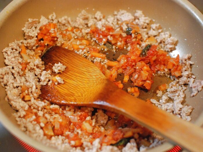 トマトソースと小麦粉を加えてミートソースを作る