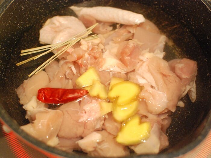 鶏肉、しょうが、赤唐辛子、レモングラスを煮る