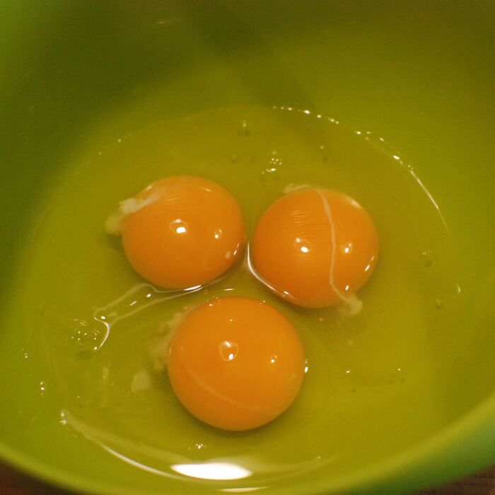 ボウルに卵を割り入れて、あさりの酒蒸しの出汁、ネギ小口切りを加えます